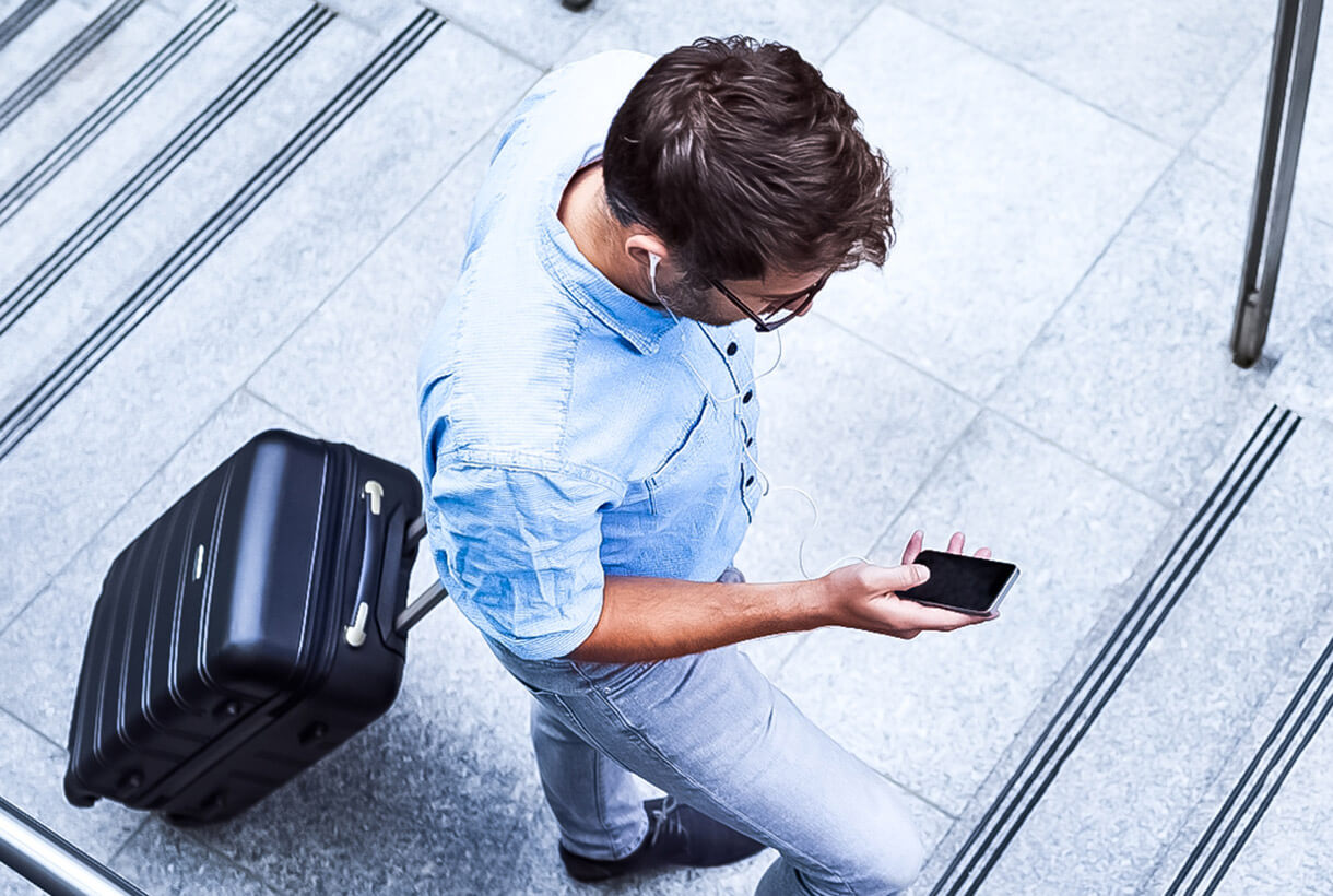 Photo of a man walking up stairs using a smartphone